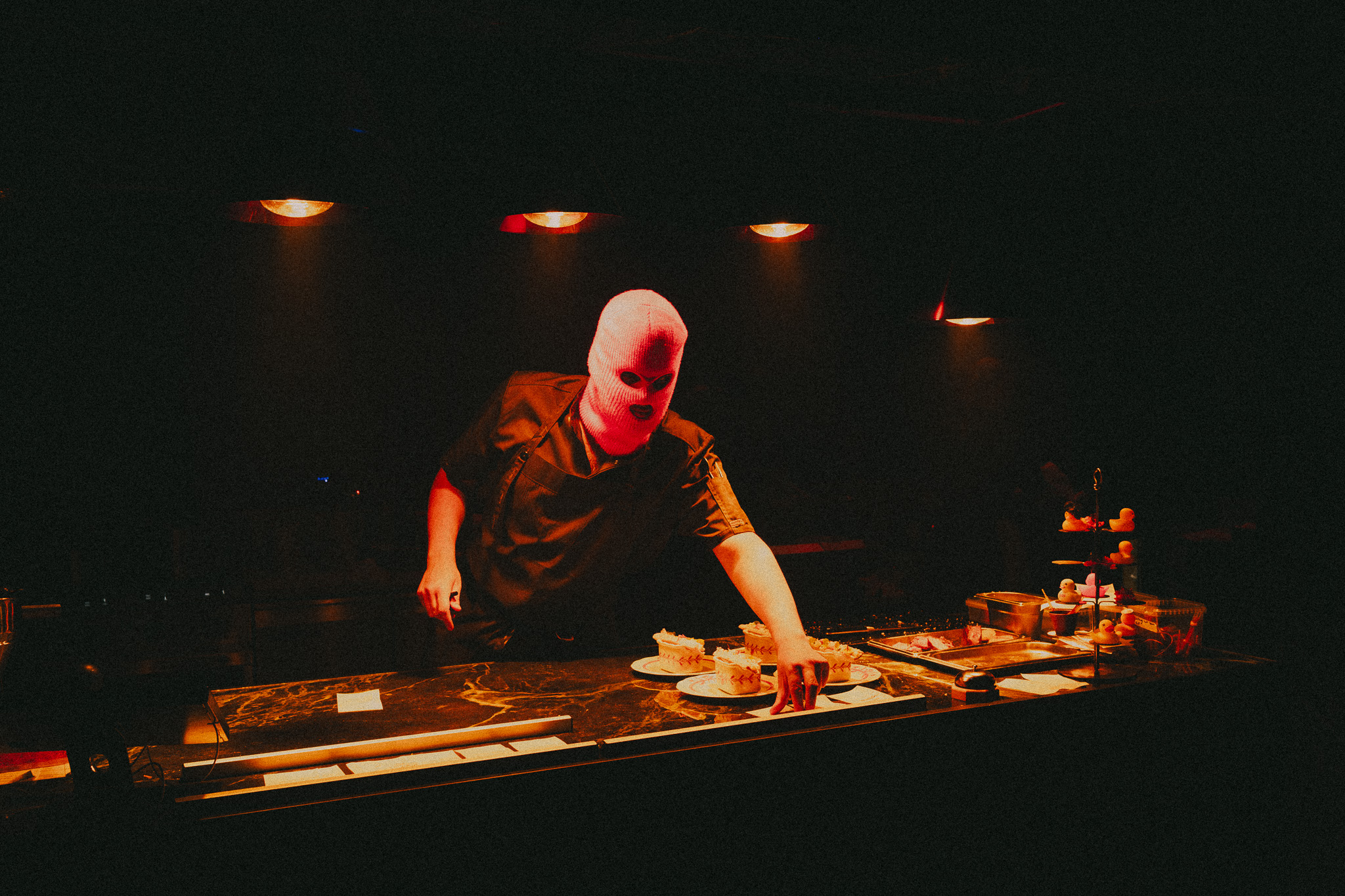 Masked chef plating at Absurd